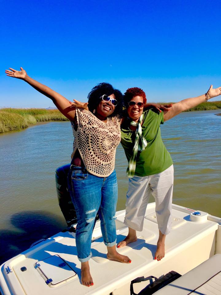 Happy friends standing on the stern on a scenic boat cruise in the Napa-Sonoma Marshes.
