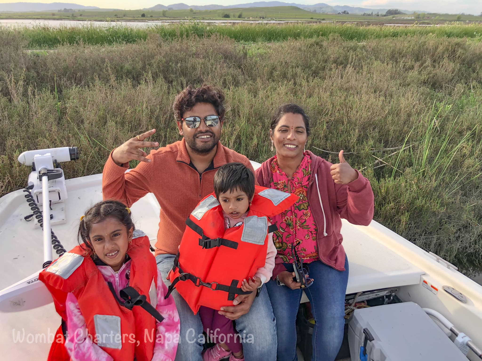 A couple with their young kids enjoying the outdoors on a Napa River cruise. Kids twelve and under must wear lifejackets while underway.
